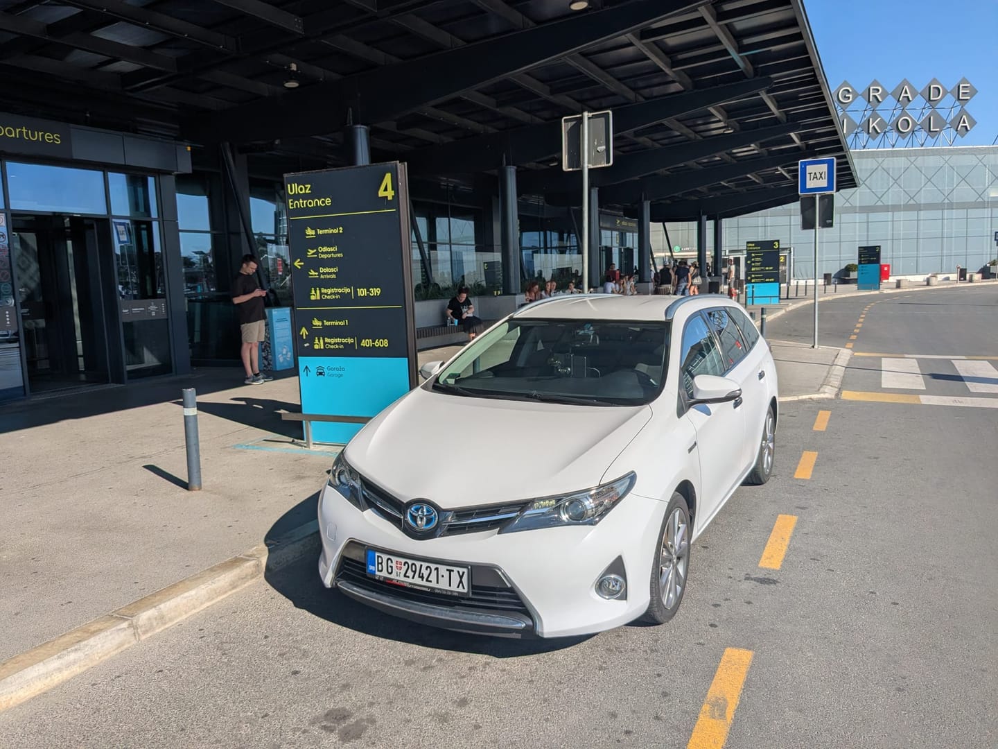 Beli Toyota Auris taxi ispred ulaza 4 Aerodroma Nikola Tesla Beograd