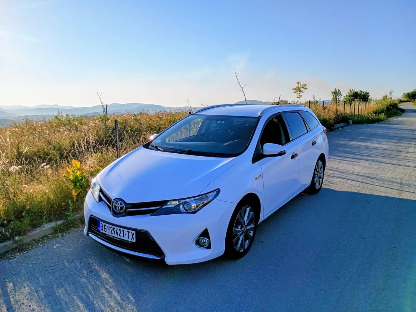 Beli Toyota Auris taxi na brdskom putu u Bosni i Hercegovini
