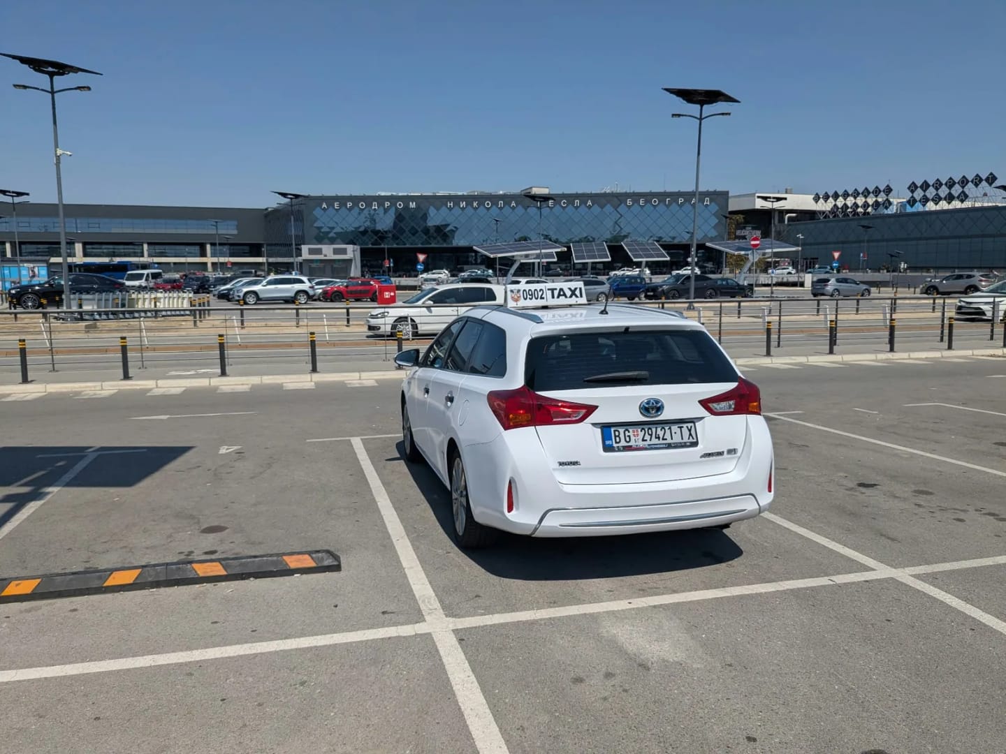 Beli Toyota Auris taxi na parkingu ispred Aerodroma Nikola Tesla Beograd